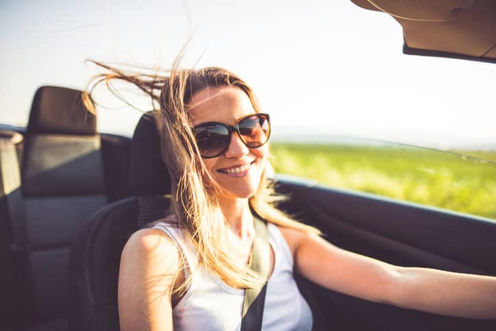 Girl driving convertible car.