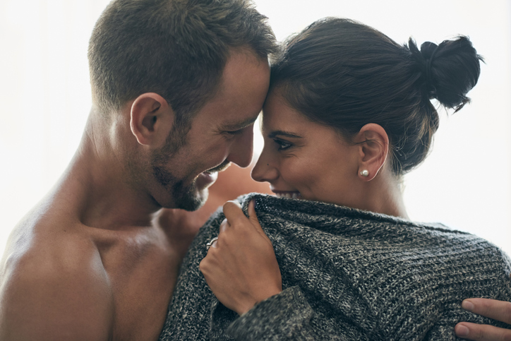 Young couple about to kiss in their bedroom.