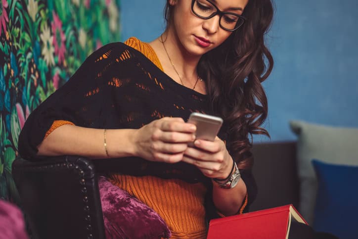 Woman experiencing FOMO and on her phone. 