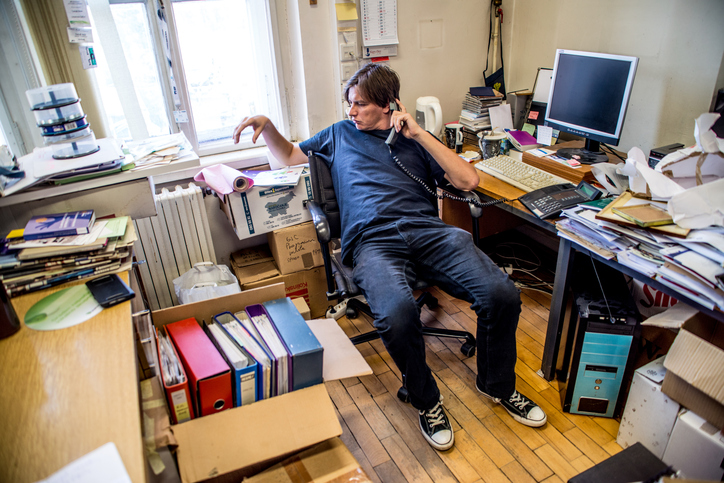 A man in a messy room.