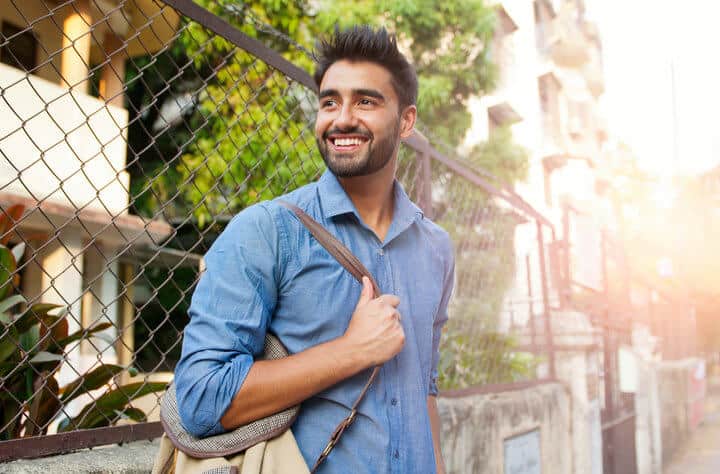 smiling guy walking down street