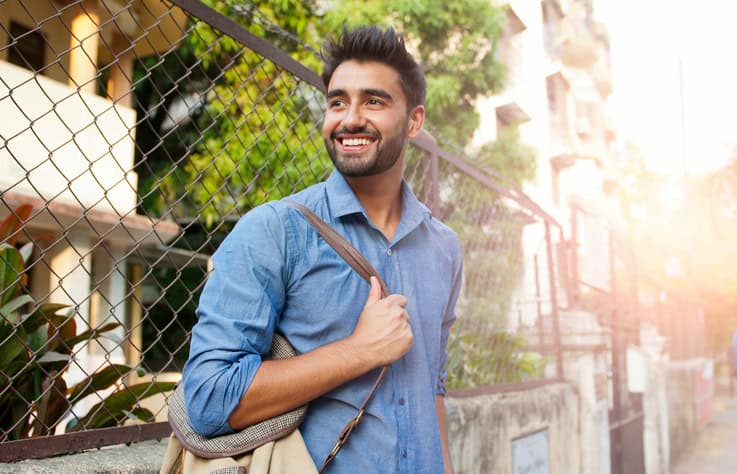 smiling guy walking down street