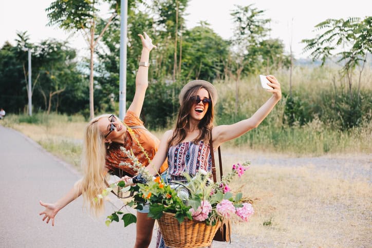 two women laughing with a bicycle