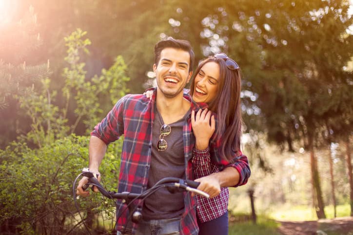Cheerful Couple Riding Bicycle Together.