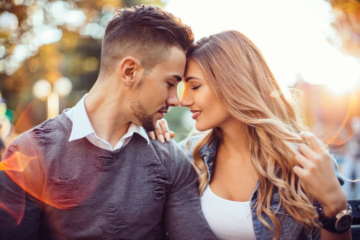 Young couple face to face sunset