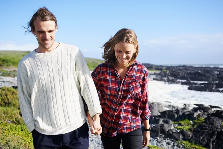 couple walking beside cliff edge
