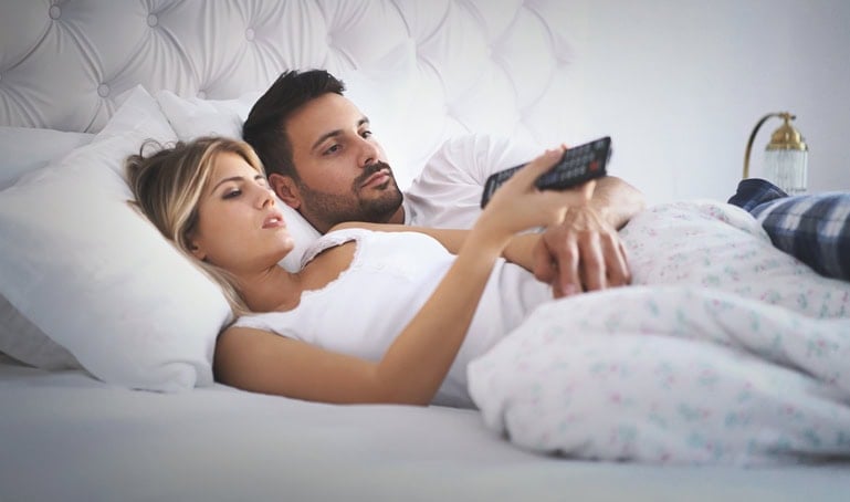 couple looking bored in bed