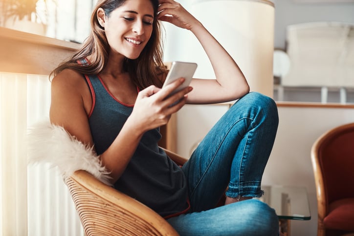 Shot of an attractive young woman using her cellphone at home