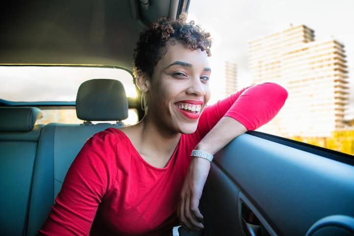 hispanic woman leaning out of the window of a car