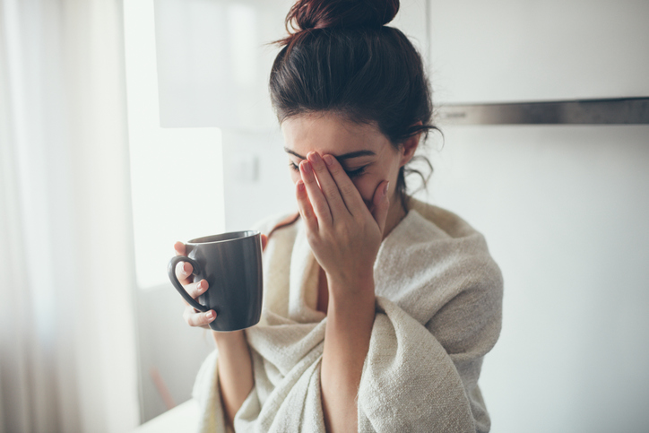 Woman having a tea or coffee looking stressed and upset