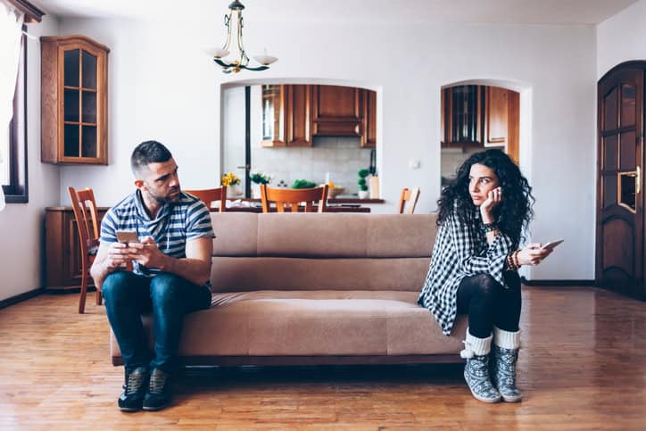 couple sitting separately on the sofa