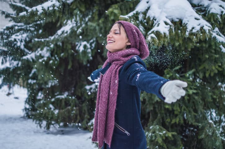 Young woman is enjoying winter day in a forest.