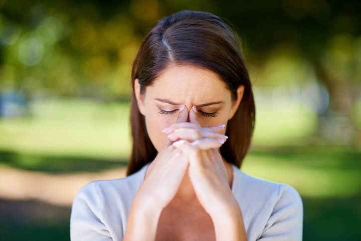 Shot of an attractive young woman looking stressed while standing outdoors