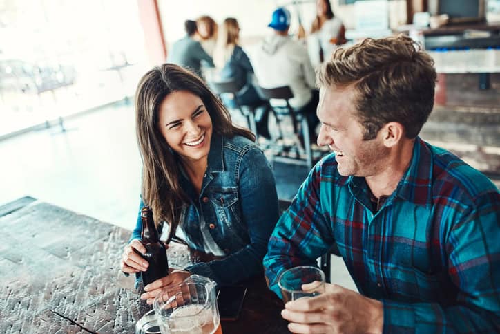 Shot of a happy young man and woman having beers at a bar