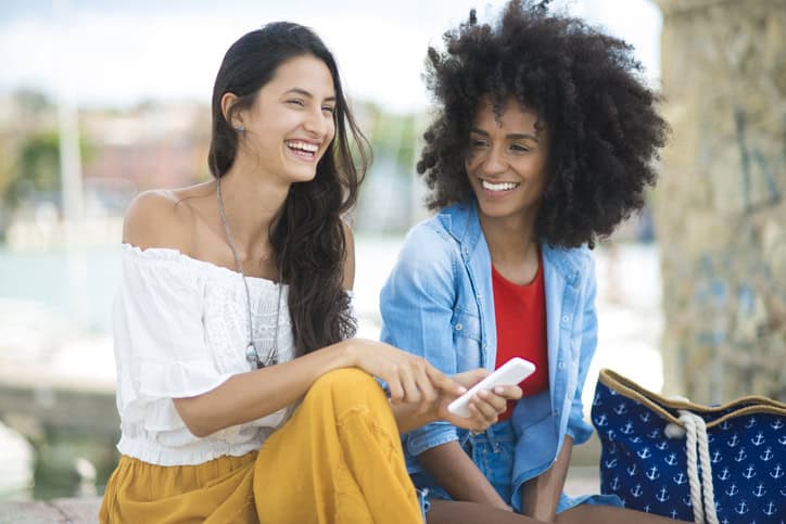 Two woman using mobile phone.