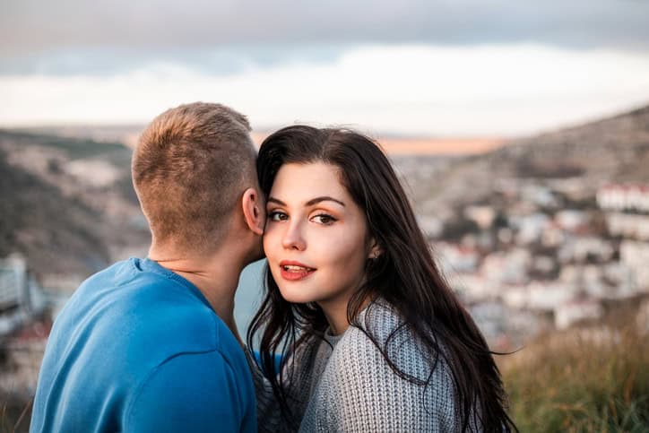 woman lookng over a man's shoulder outside