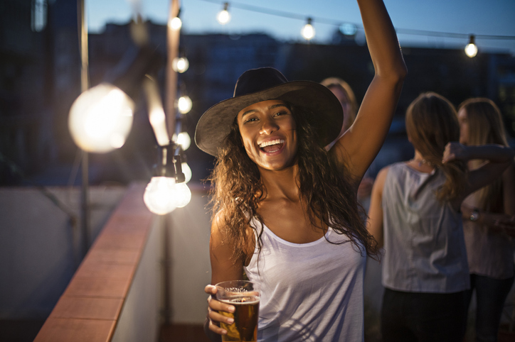Woman dancing and drinking alcohol.