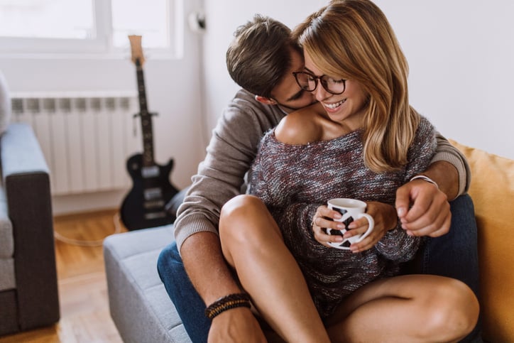 Happy Young Couple Enjoying Free Time On Coffee Break At Home