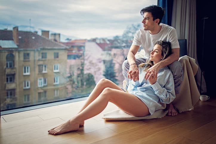 Young couple is looking the city view in the cold morning from their flat