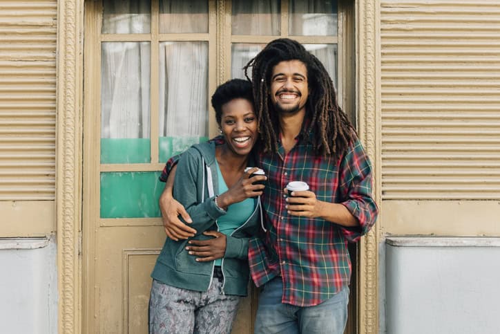 black couple outside house smiling