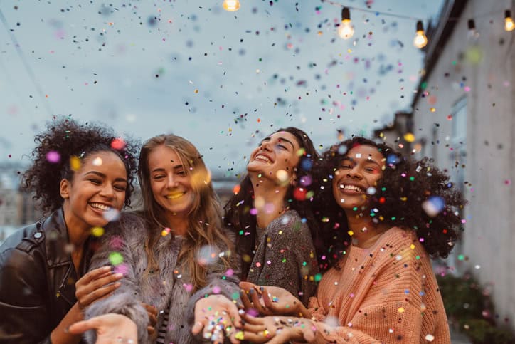 four women celebrating with glitter