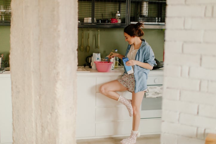 Woman standing in her kitchen.