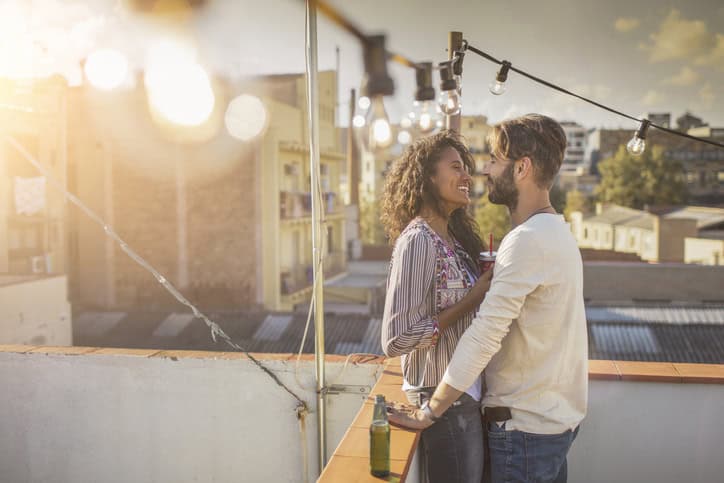 Affectionate couple together on a rooftop party