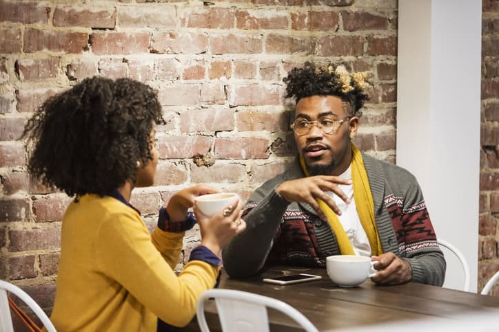 Young mixed race couple talking in coffee shop