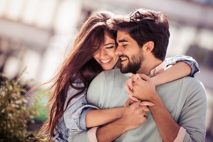 Happy young couple having fun outdoors and smiling.