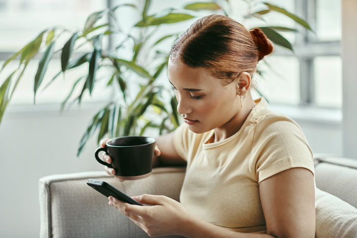 Woman texting and drinking coffee.