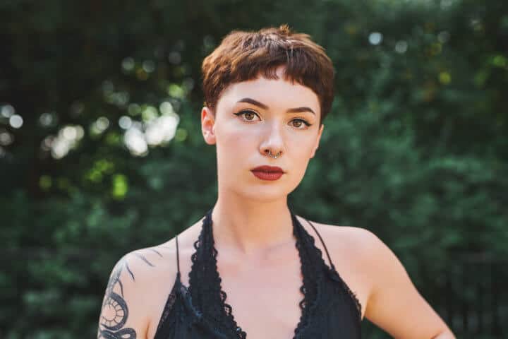 woman short hair black dress foliage