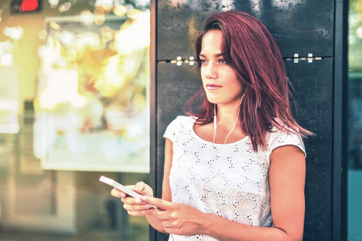 red headed woman holding her smart phone