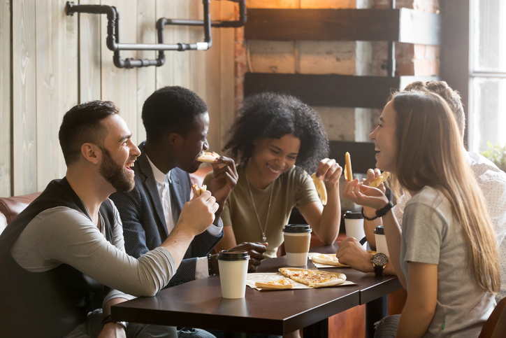 Friends eating pizza at a restaurant.