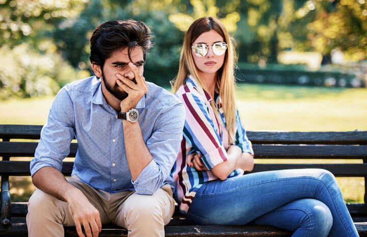upset couple having fight on park bench
