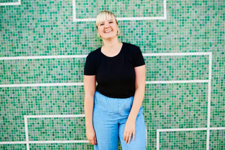 smiling woman against green wall
