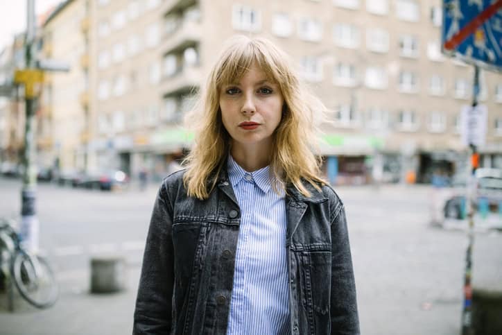 young blonde woman standing in the street
