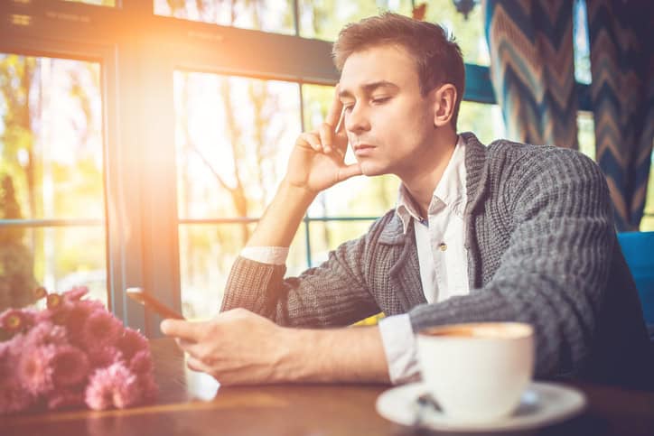 serious man with phone in restaurant