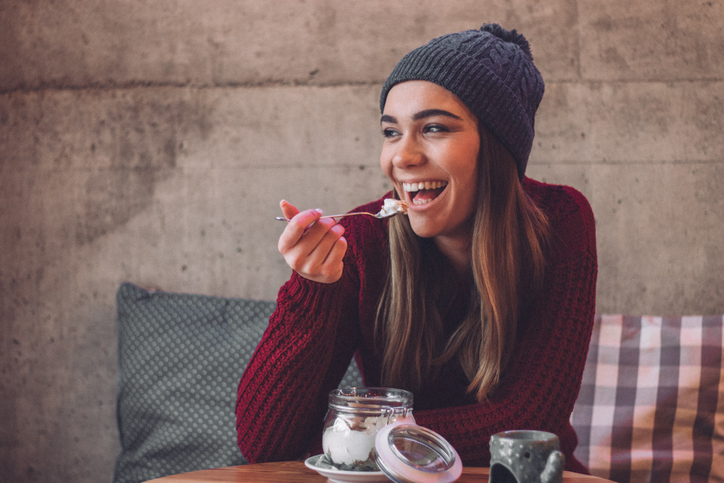 woman in beanie eating yoghurt