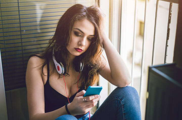 woman with headphones texting