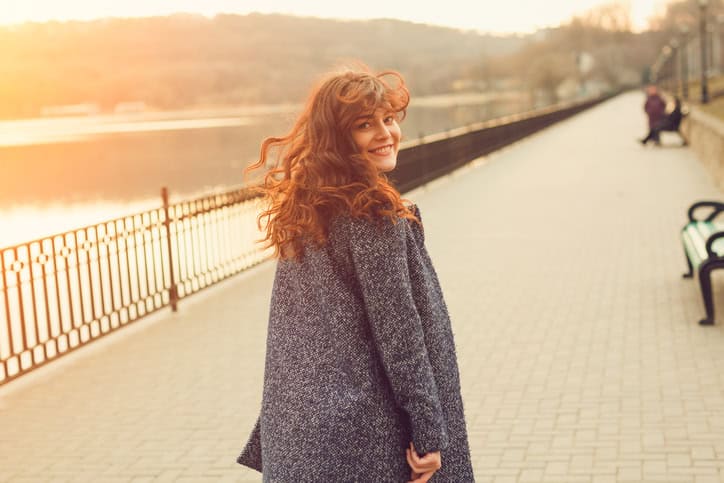 curly haired ginger woman smiling