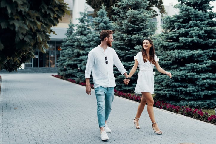 couple holding hands walking outside