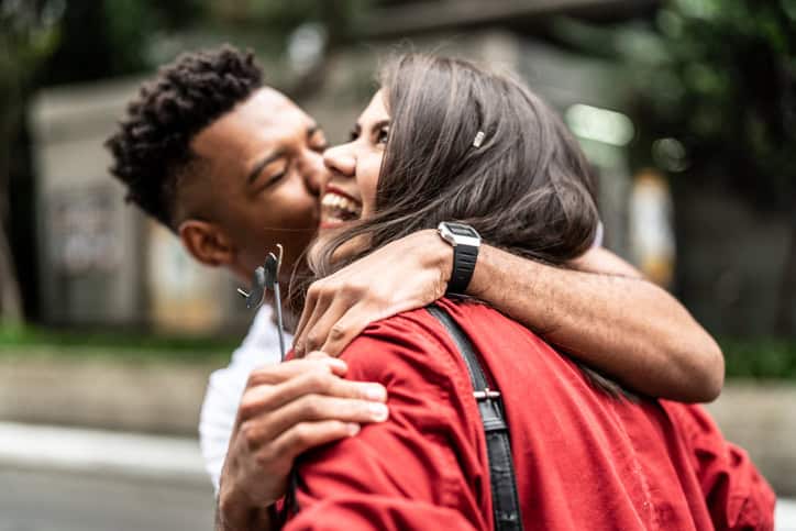 happy guy kissing girl on cheek