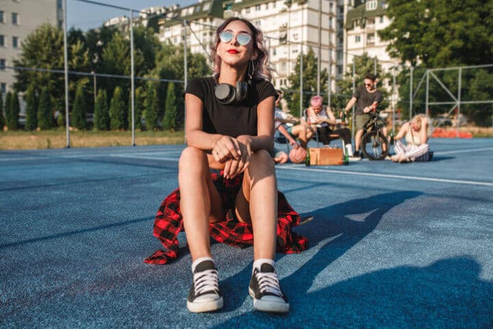 hipster woman sitting in ball park