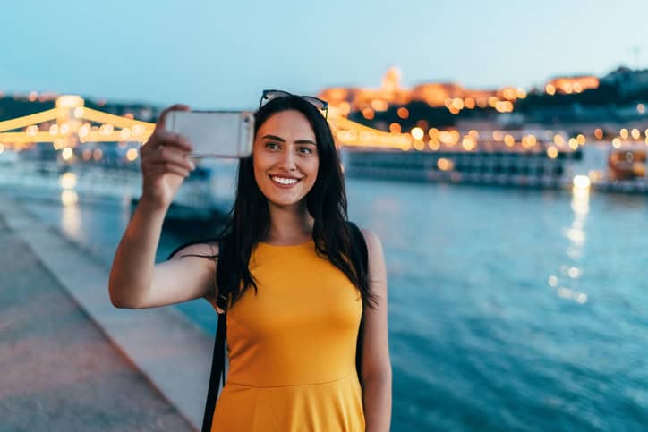 beautiful woman in orange dress taking selfie