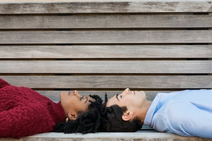 couple laying down heads touching