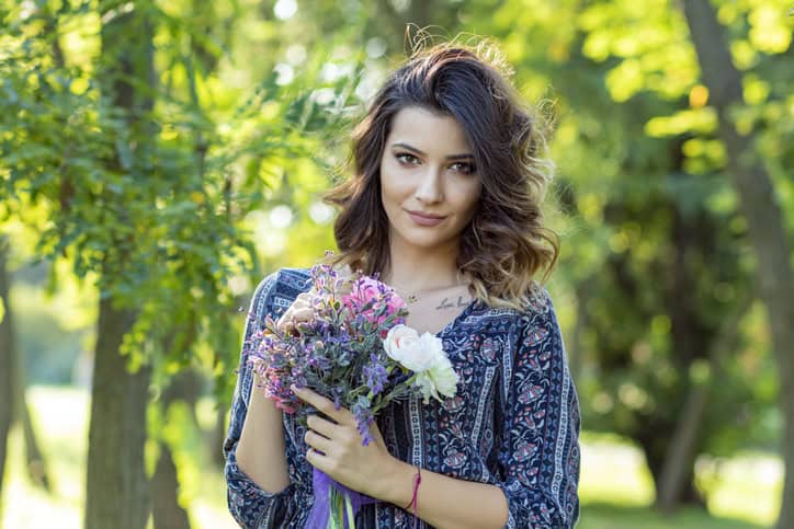Long Haired Young Woman Holding a Flowers