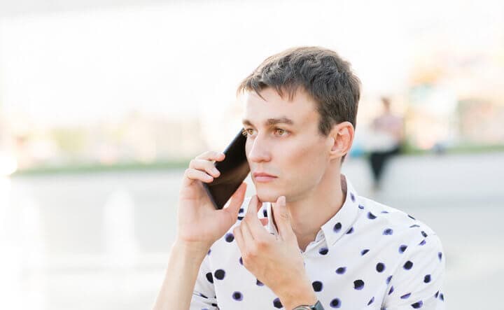 pensive guy on phone outside