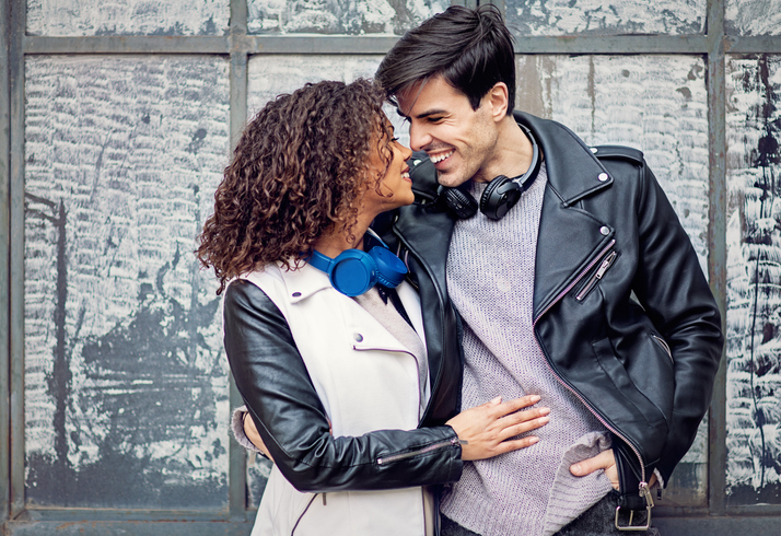 couple wearing headphones smiling