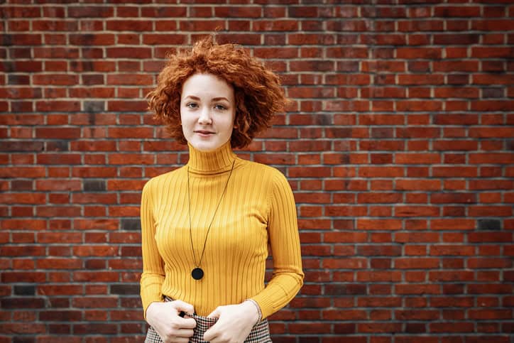 woman in yellow with ginger curly hair