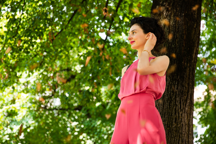Young woman standing alone outside.